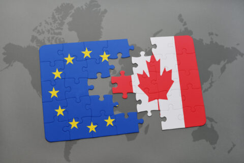 A puzzle with the national flag of Canada and the European Union on a world map.
