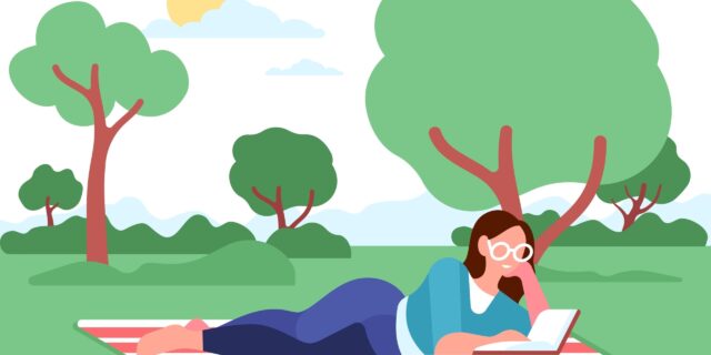 A woman sits on a picnic blanket while reading a book outside. It is a sunny summer day.