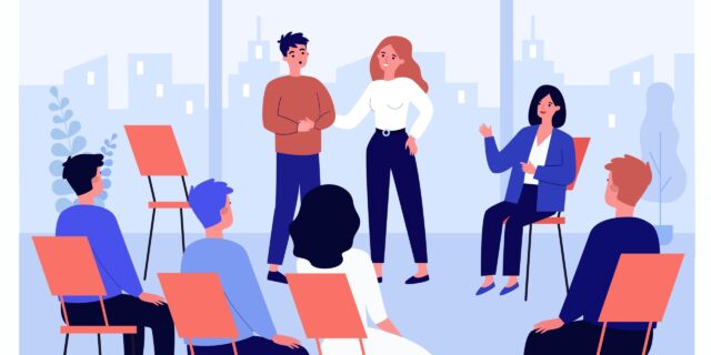 Some coworkers sit in a group, listening to a speaker. Workplace learning and mental health